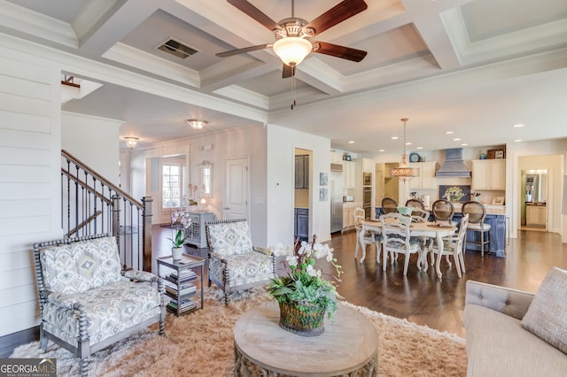 living room featuring dark wood-style flooring, coffered ceiling, visible vents, stairs, and beamed ceiling