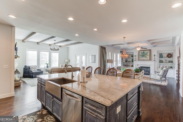 kitchen featuring beam ceiling, open floor plan, dishwasher, and a sink