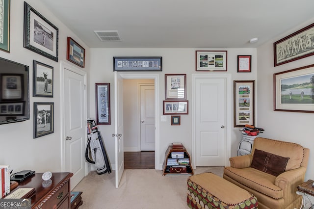 sitting room featuring light carpet, visible vents, and baseboards