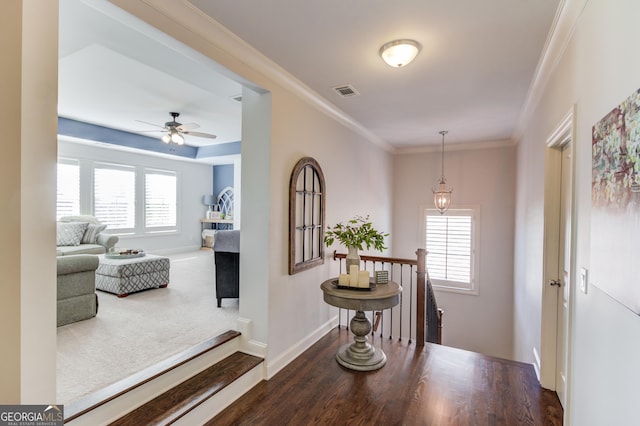 hallway featuring crown molding, visible vents, an upstairs landing, wood finished floors, and baseboards