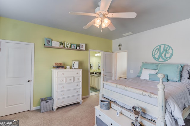 bedroom featuring visible vents, light carpet, ceiling fan, ensuite bath, and baseboards