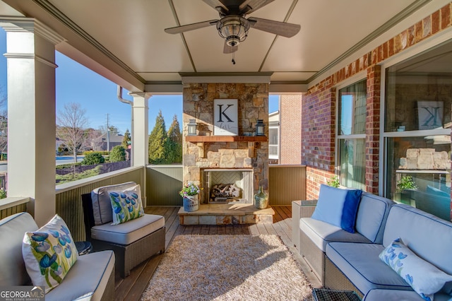 view of patio featuring an outdoor living space with a fireplace and a ceiling fan