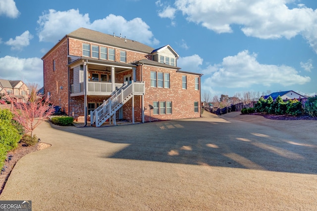 back of property with stairway and brick siding