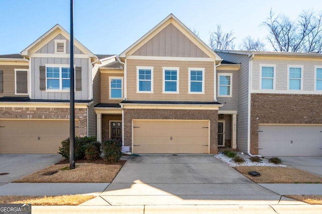 townhome / multi-family property featuring concrete driveway, brick siding, and board and batten siding