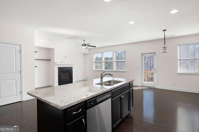 kitchen featuring dark wood finished floors, open floor plan, a sink, dark cabinets, and dishwasher