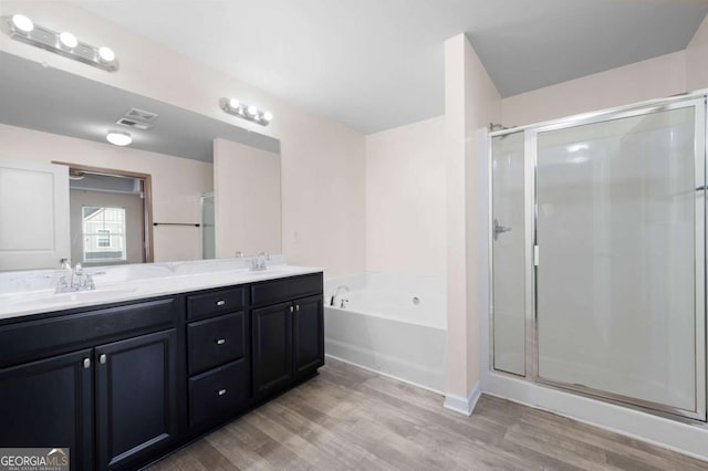 full bathroom featuring a bath, a stall shower, visible vents, and a sink