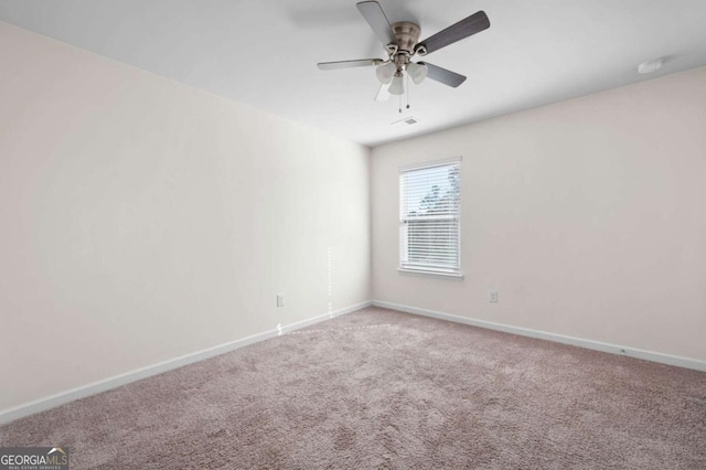 spare room featuring carpet, visible vents, baseboards, and ceiling fan