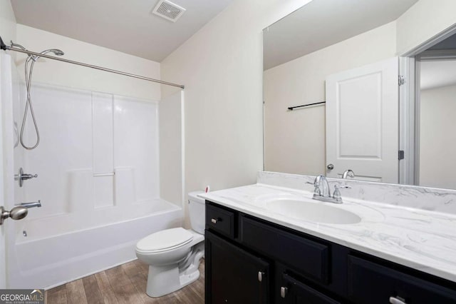 bathroom with visible vents, toilet, wood finished floors, bathtub / shower combination, and vanity