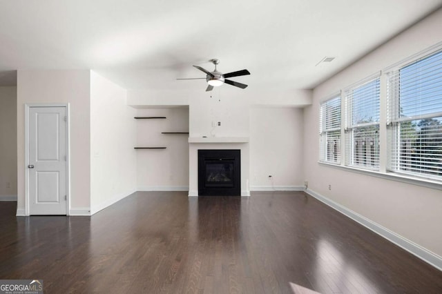 unfurnished living room with ceiling fan, baseboards, wood finished floors, and a glass covered fireplace