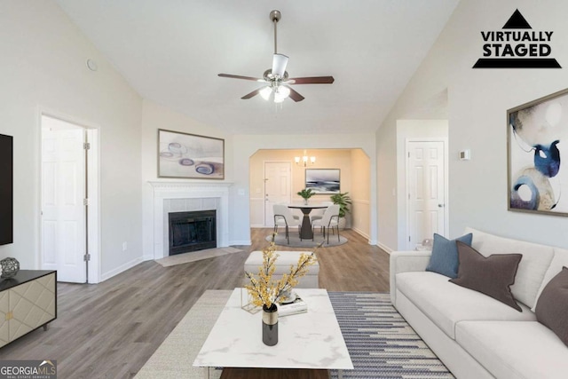 11139 Silver Aspen Ct, Hampton, GA 30228 - living room featuring lofted ceiling, a ceiling fan, wood finished floors, a chandelier, and a tiled fireplace