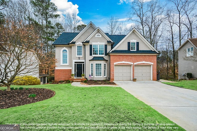 traditional home with a garage, brick siding, driveway, stucco siding, and a front yard