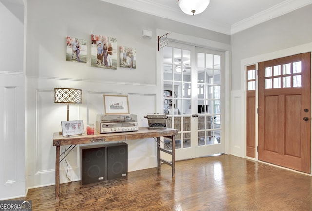 foyer entrance with wood finished floors, a ceiling fan, french doors, wainscoting, and crown molding