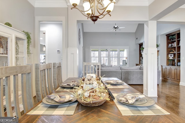 dining room featuring ornate columns, ornamental molding, wood finished floors, and ceiling fan with notable chandelier