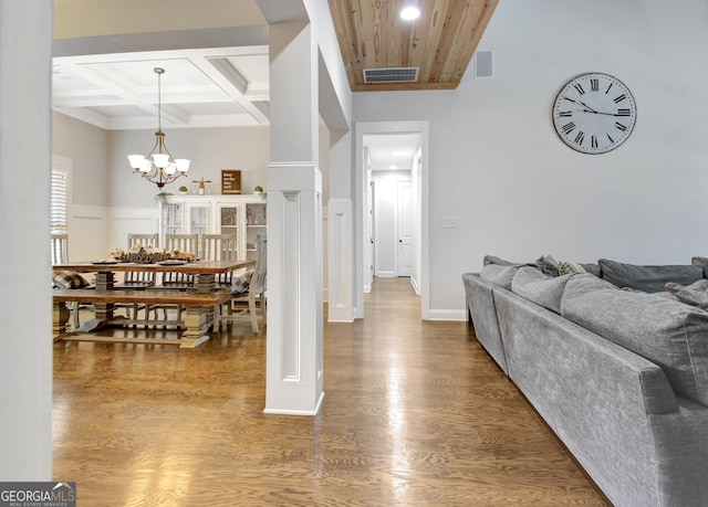 interior space with beam ceiling, visible vents, wood finished floors, a chandelier, and coffered ceiling