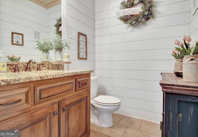 bathroom with a fireplace, vanity, toilet, and tile patterned floors