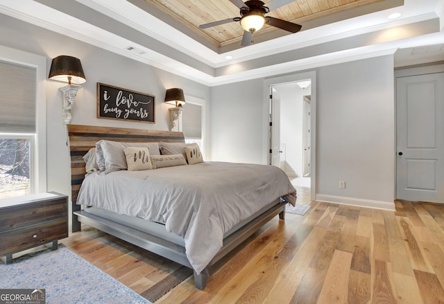 bedroom with visible vents, a raised ceiling, wood ceiling, ornamental molding, and light wood-style floors