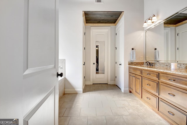 bathroom with visible vents, vanity, baseboards, and tile patterned floors