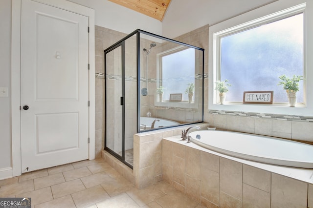 bathroom with a shower stall, vaulted ceiling, a bath, and tile patterned floors