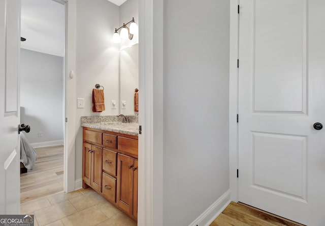 bathroom with tile patterned flooring, vanity, and baseboards