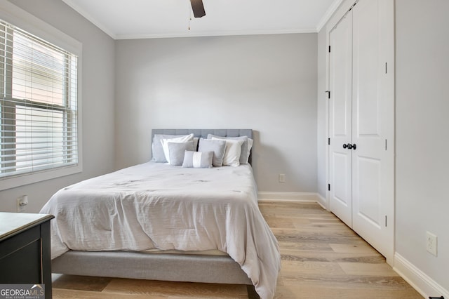 bedroom with ornamental molding, ceiling fan, light wood finished floors, and baseboards