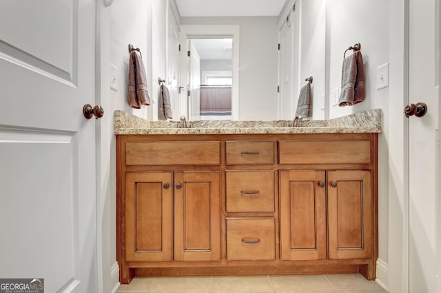 full bathroom featuring double vanity, a sink, and tile patterned floors