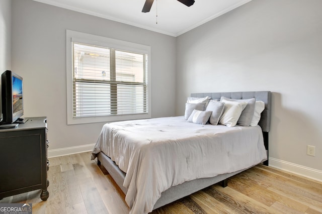 bedroom featuring crown molding, baseboards, a ceiling fan, and light wood-style floors