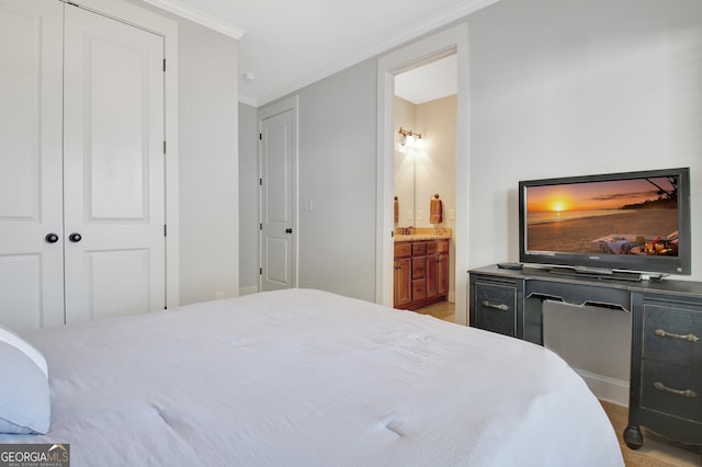 bedroom featuring ornamental molding, a closet, and ensuite bath