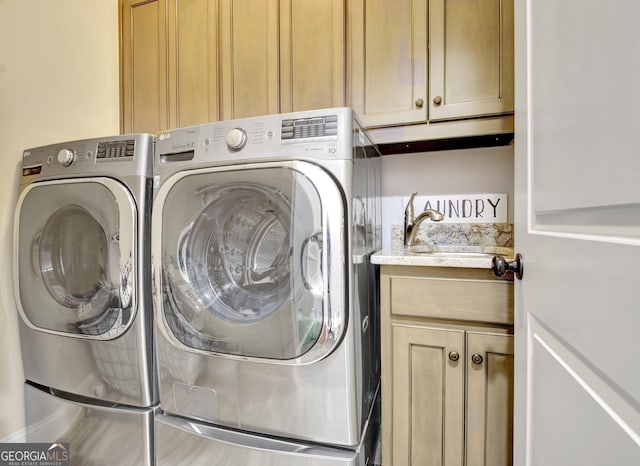 laundry area featuring cabinet space, a sink, and independent washer and dryer