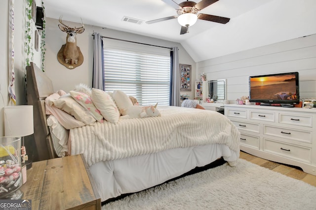 bedroom featuring ceiling fan, light wood-style flooring, visible vents, and vaulted ceiling