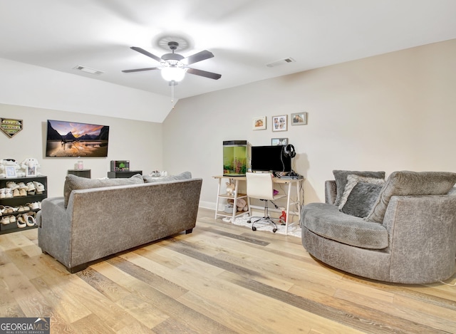 living room featuring light wood-style flooring, visible vents, vaulted ceiling, and a ceiling fan