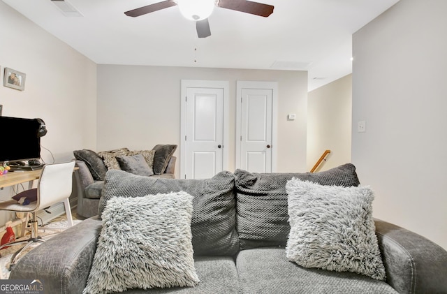 living area featuring a ceiling fan and visible vents