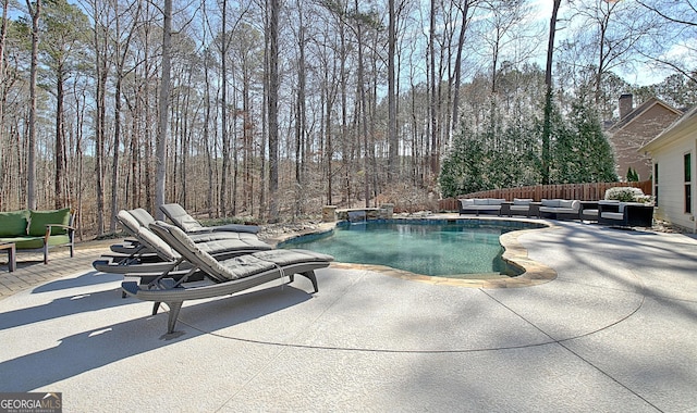 outdoor pool featuring a patio, fence, and an outdoor hangout area