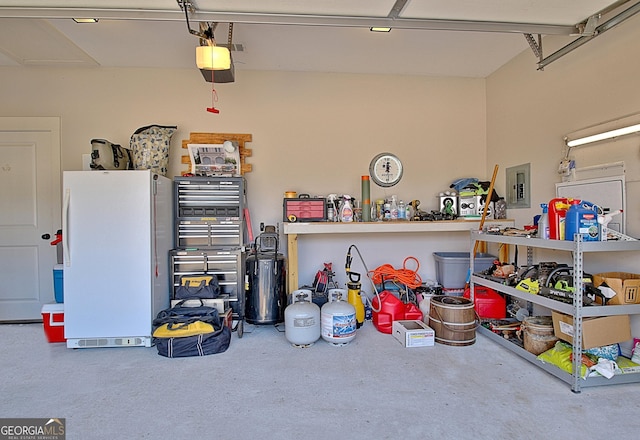 garage featuring a garage door opener, freestanding refrigerator, and electric panel