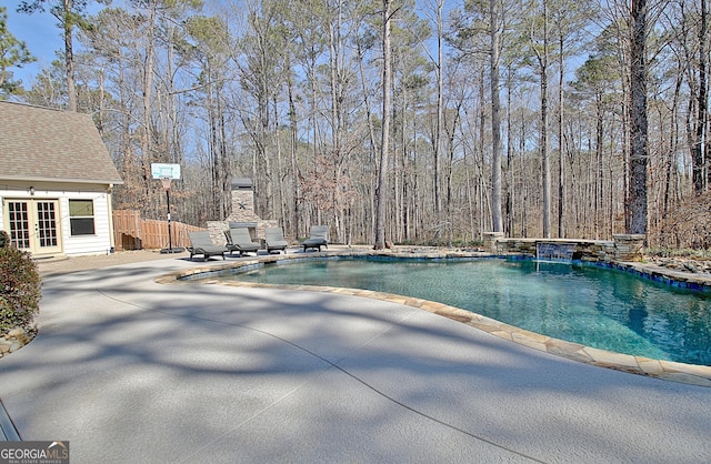 pool featuring french doors, a patio, and fence