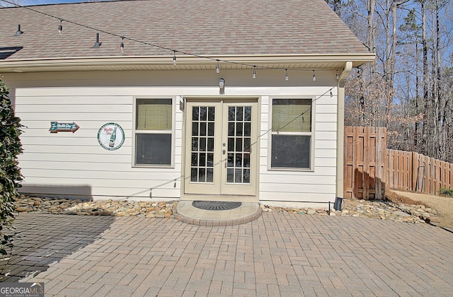 exterior space featuring a shingled roof, french doors, a patio area, and fence