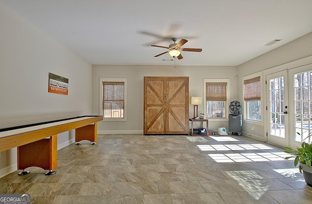 recreation room with french doors, visible vents, stone finish flooring, and baseboards