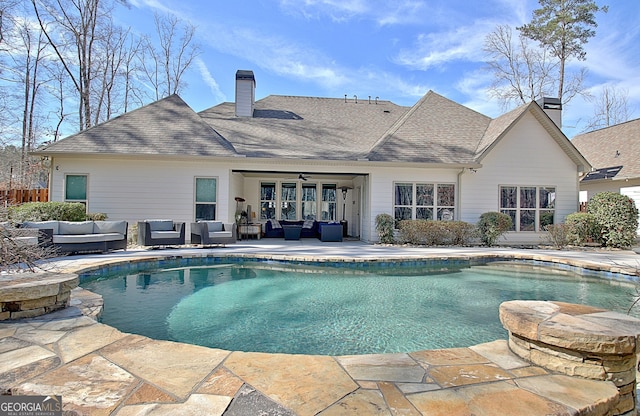 pool with ceiling fan, a patio, and an outdoor living space