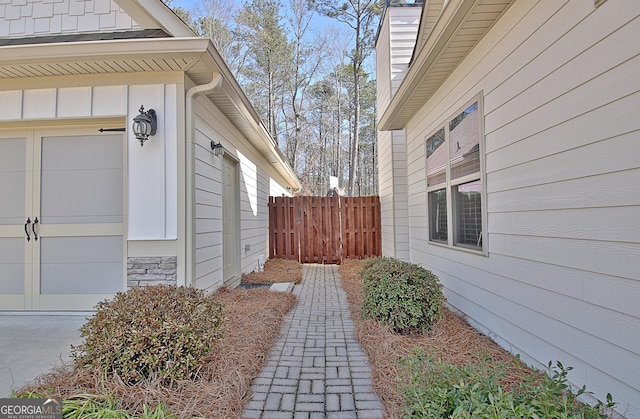 view of side of property with an attached garage and fence