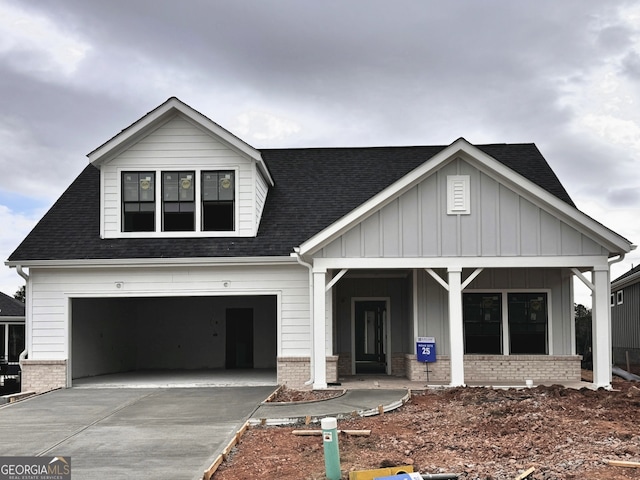 modern inspired farmhouse featuring brick siding, board and batten siding, concrete driveway, and an attached garage