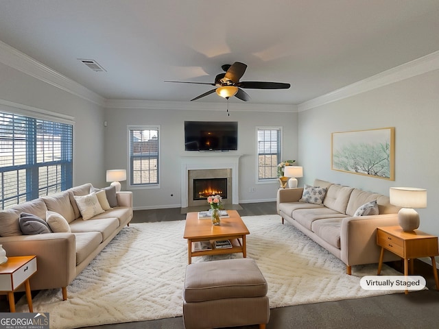 living room with baseboards, a fireplace with flush hearth, visible vents, and crown molding