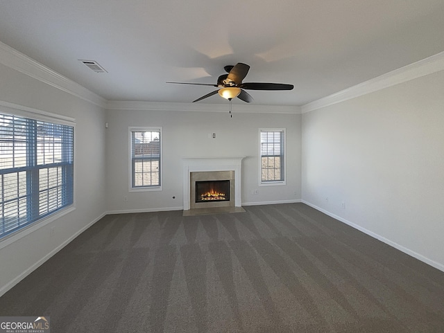 unfurnished living room featuring ornamental molding, dark colored carpet, and a high end fireplace