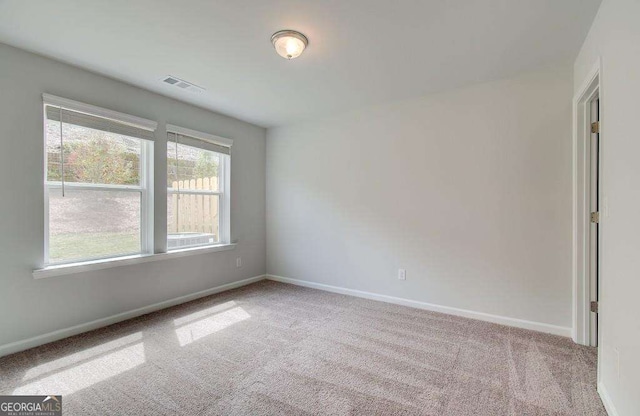 empty room featuring visible vents, baseboards, and carpet floors