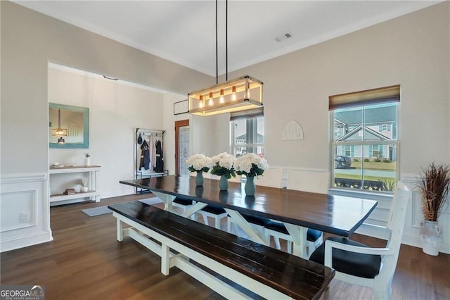 dining space with dark wood-style floors, visible vents, a decorative wall, and wainscoting