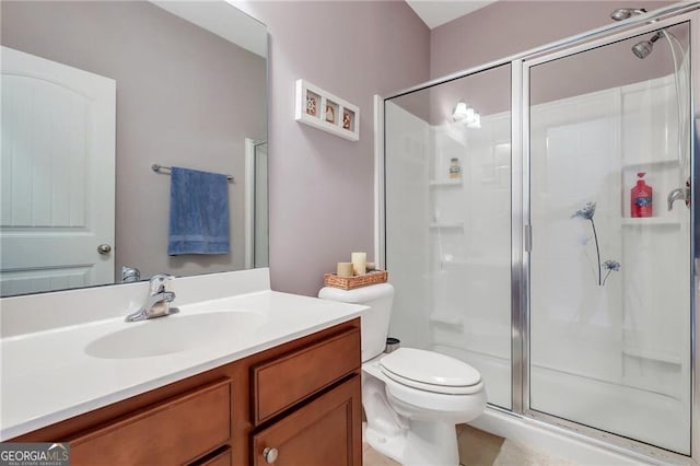 bathroom with toilet, a stall shower, and vanity