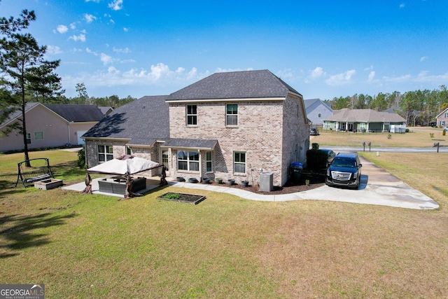 back of property featuring a vegetable garden, brick siding, a yard, and roof with shingles