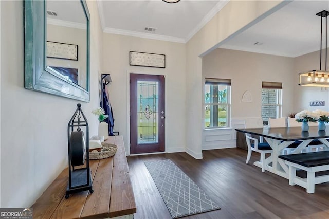 entrance foyer featuring dark wood-style floors, visible vents, and crown molding