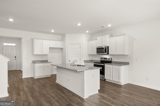 kitchen featuring a kitchen island with sink, stainless steel appliances, dark wood-style flooring, a sink, and white cabinets