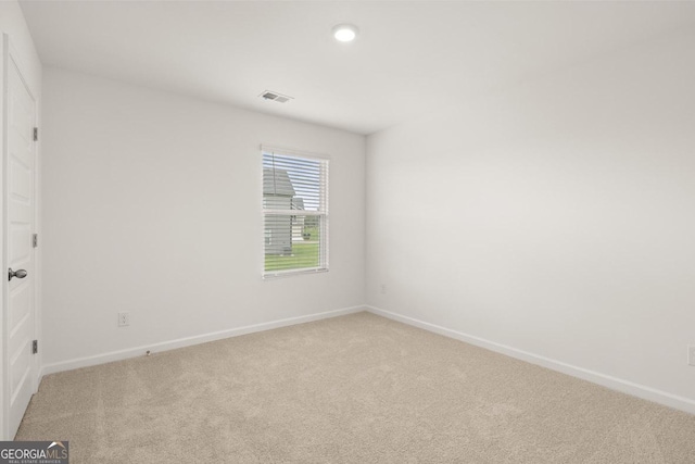 unfurnished room with recessed lighting, light colored carpet, visible vents, and baseboards