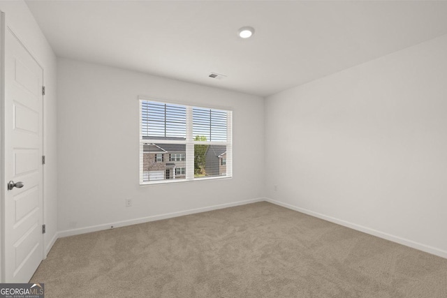 spare room featuring baseboards, visible vents, and carpet flooring