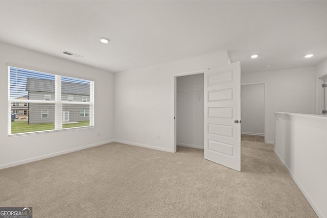 unfurnished bedroom featuring recessed lighting, visible vents, light carpet, and baseboards